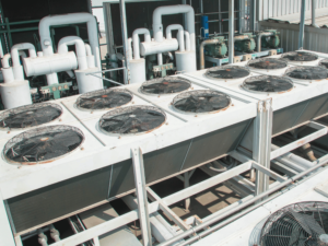 Industrial HVAC system with cooling fans and pipes for HVAC refrigerants used in temperature control.