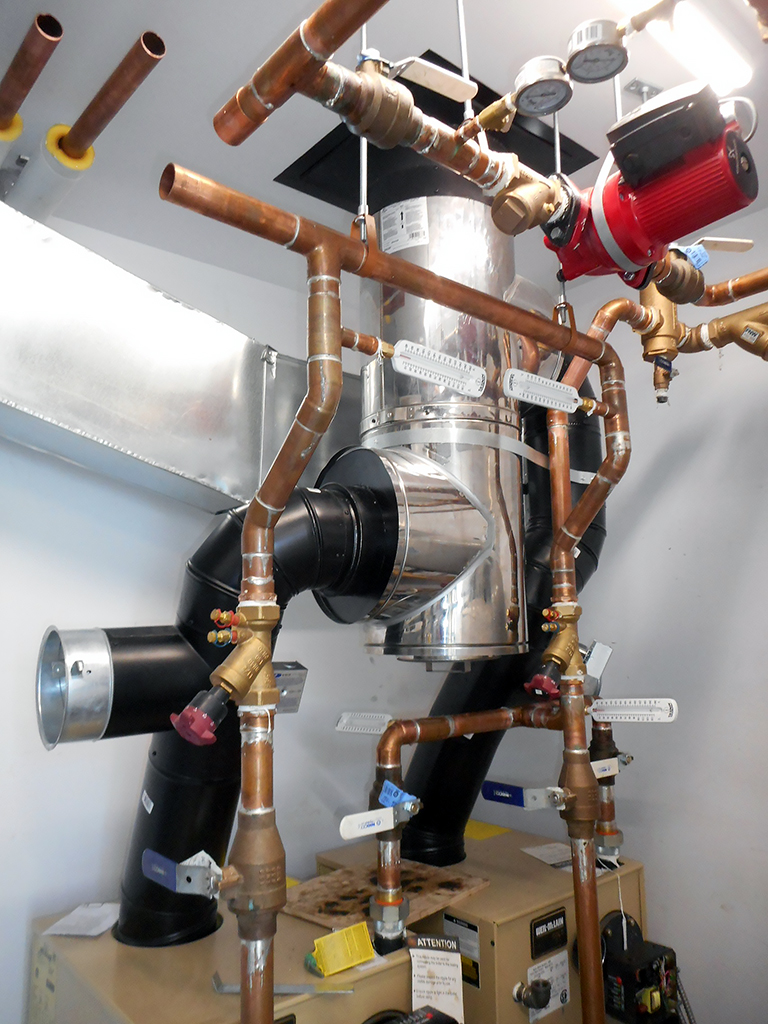 Grise Fiord 3 Copper hydronic piping with red circulator pump inside Grise Fiord Community Learning & Childcare Facility mechanical room.