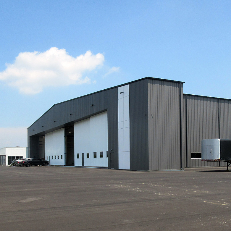 Latitude Air Ambulance hangar—a grey steel building with large white aircraft doors on the tarmac.