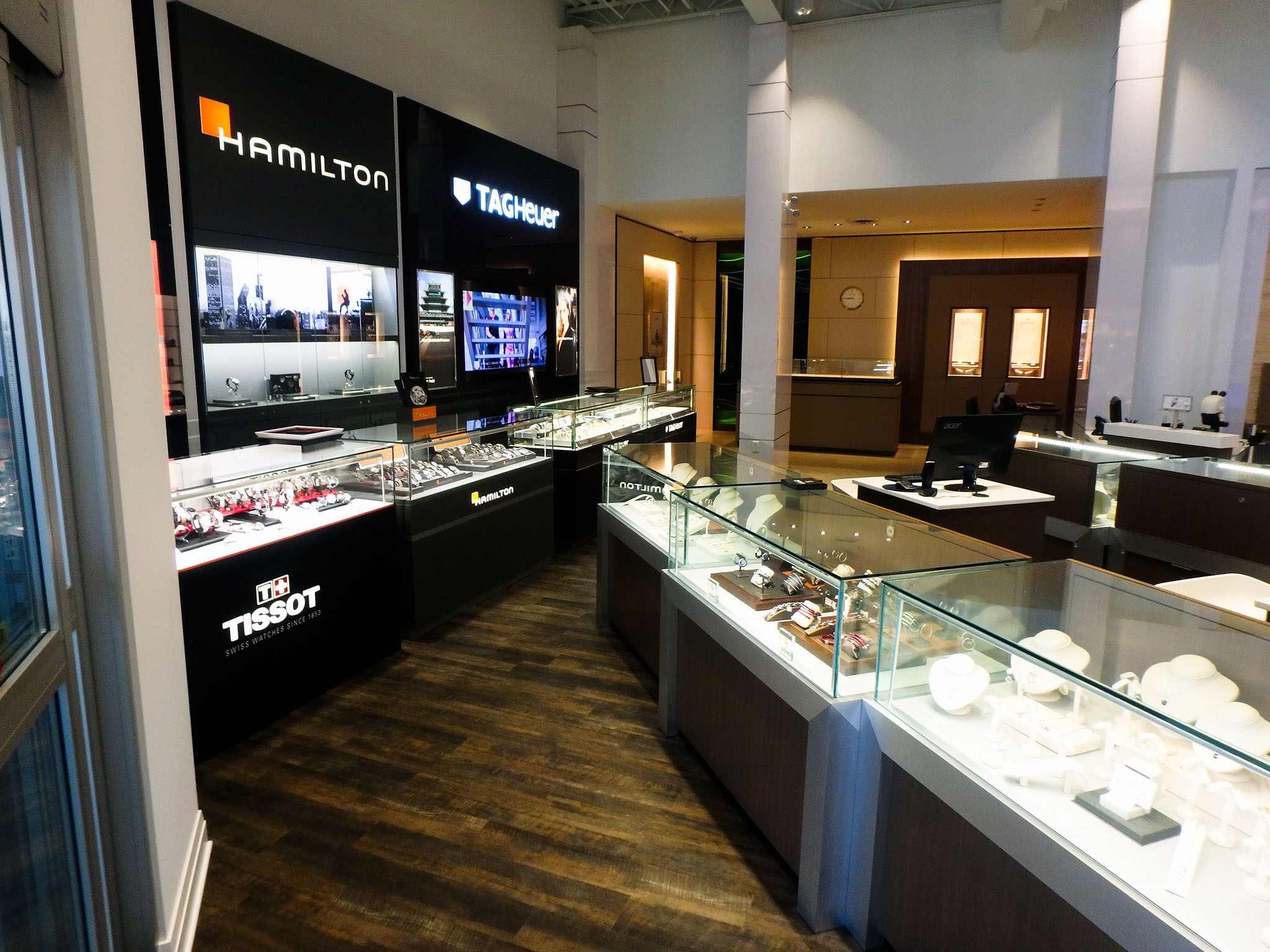 Nash Jewellers 3 Watch boutique at Nash Jewellers featuring illuminated Hamilton, TAG Heuer, and Tissot brand displays beside glass-topped counters on a wood-grain floor.