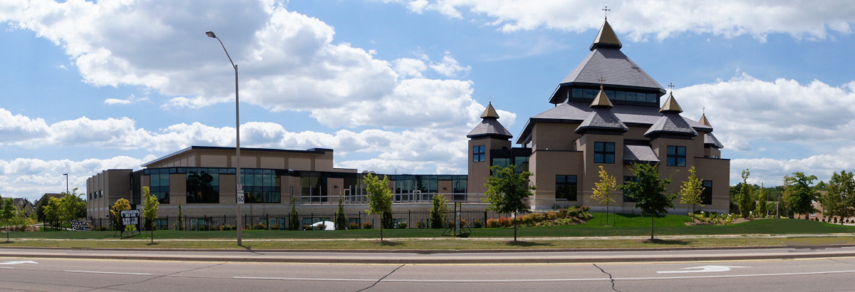 Wide view of St. Joseph’s Ukrainian Catholic Church from the street, showing the gold-domed towers and modern glass addition.