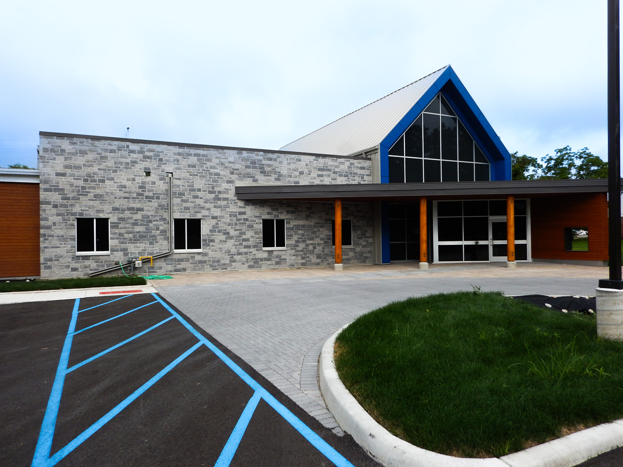 L'Arche 18 Exterior of the L’Arche Community Gathering Facility showing stone façade, wood accents, and accessible entrance.