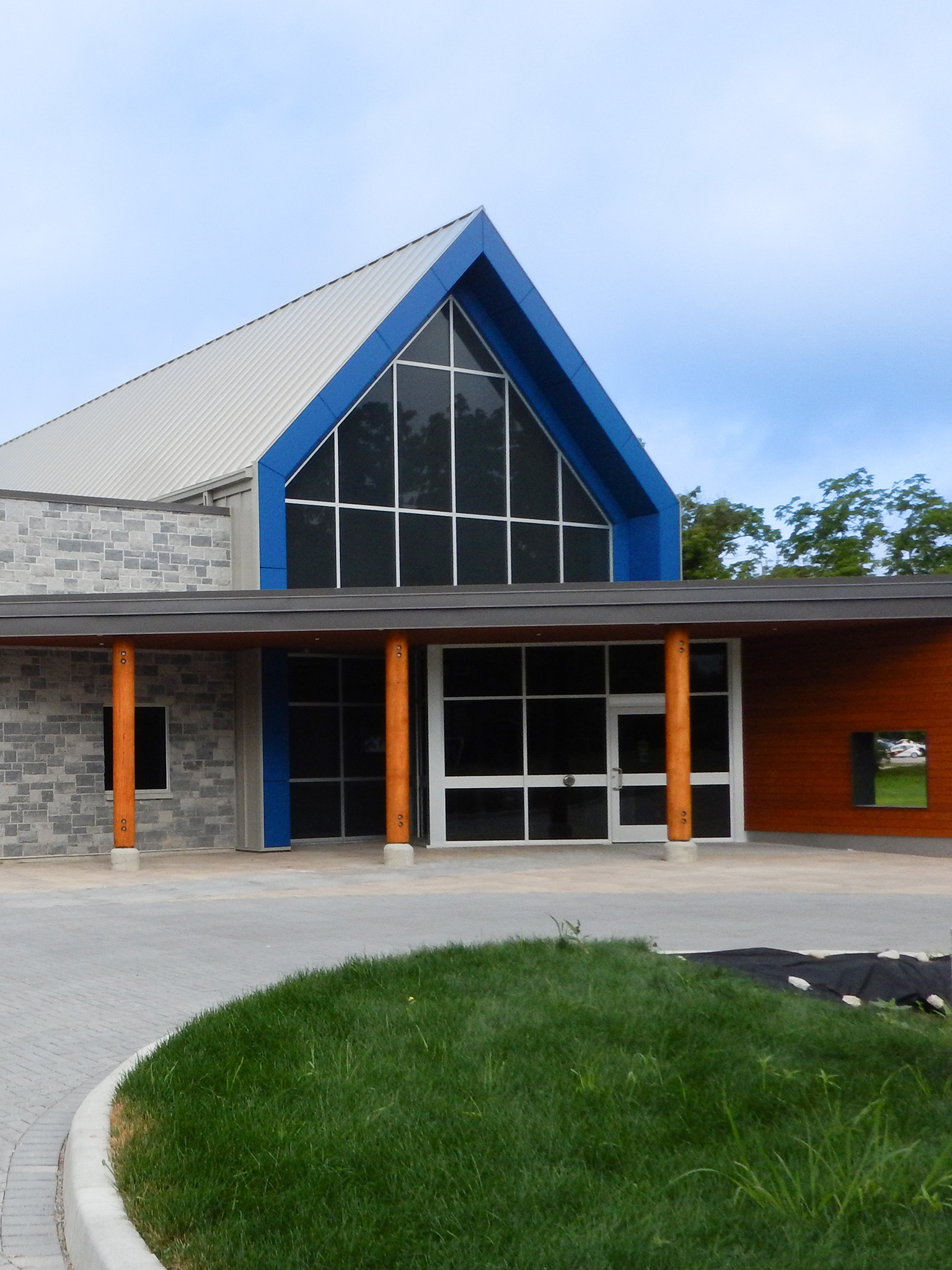 L'Arche 19 Front entrance of the L’Arche Community Gathering Facility with stone walls, wood columns, and tall gabled windows.