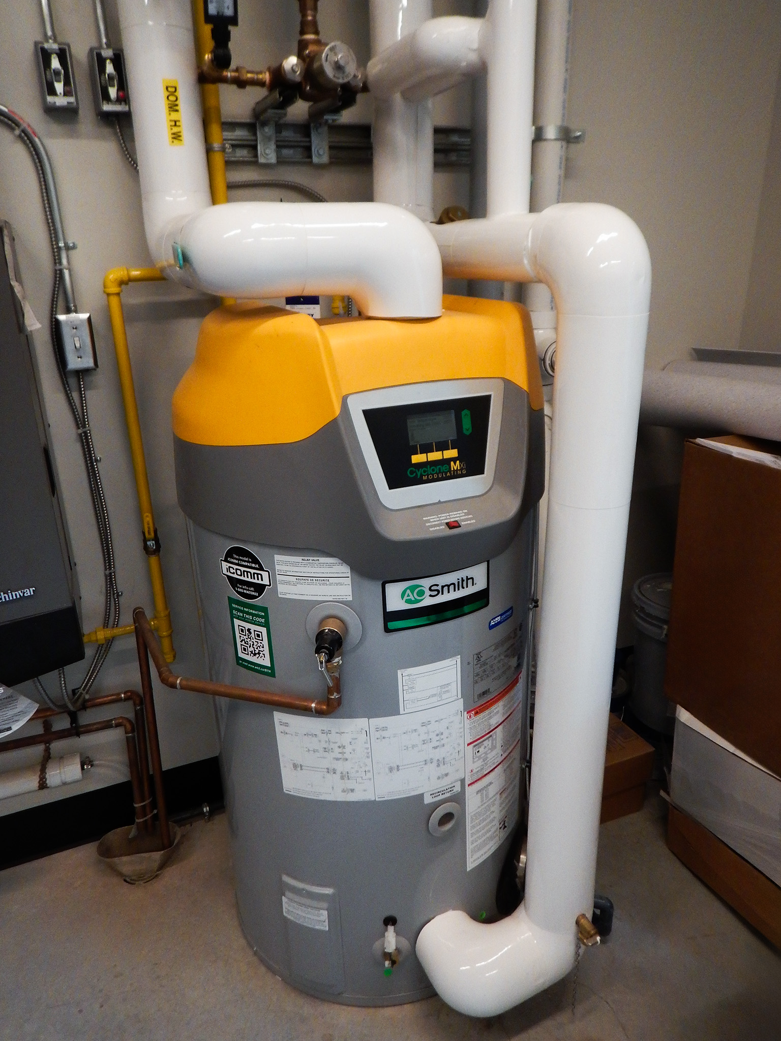 L'Arche 20 AO Smith Cyclone hot water heater with insulated piping inside the L’Arche Gathering Facility mechanical room.