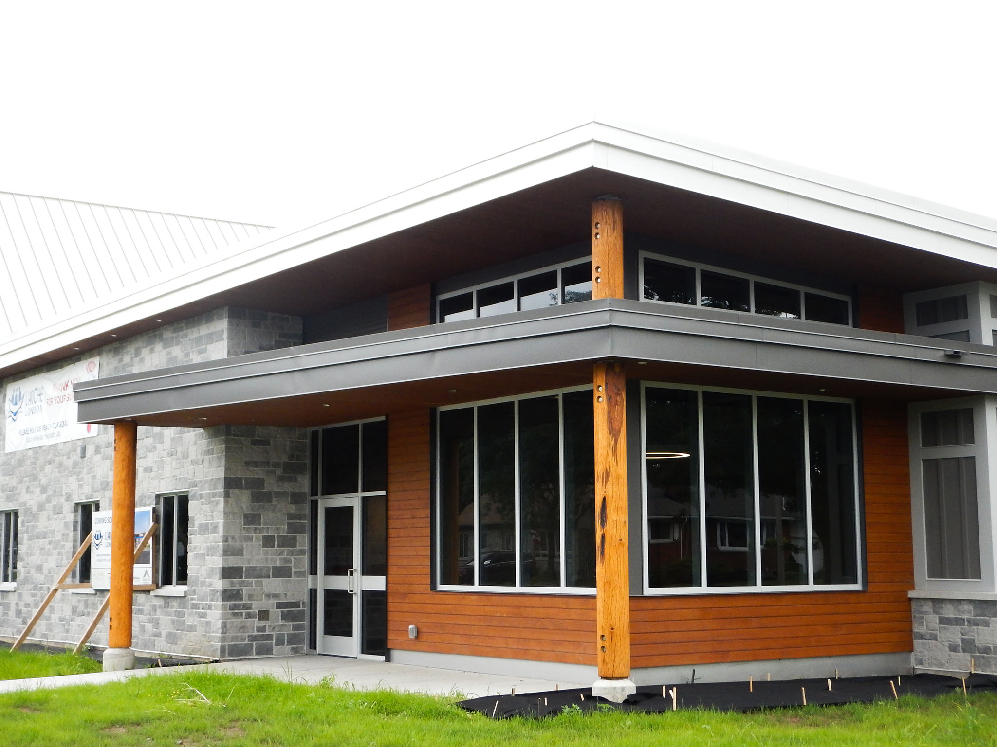 L'Arche 7 Corner entrance of the L’Arche Community Gathering Facility with stone and wood exterior and large windows.