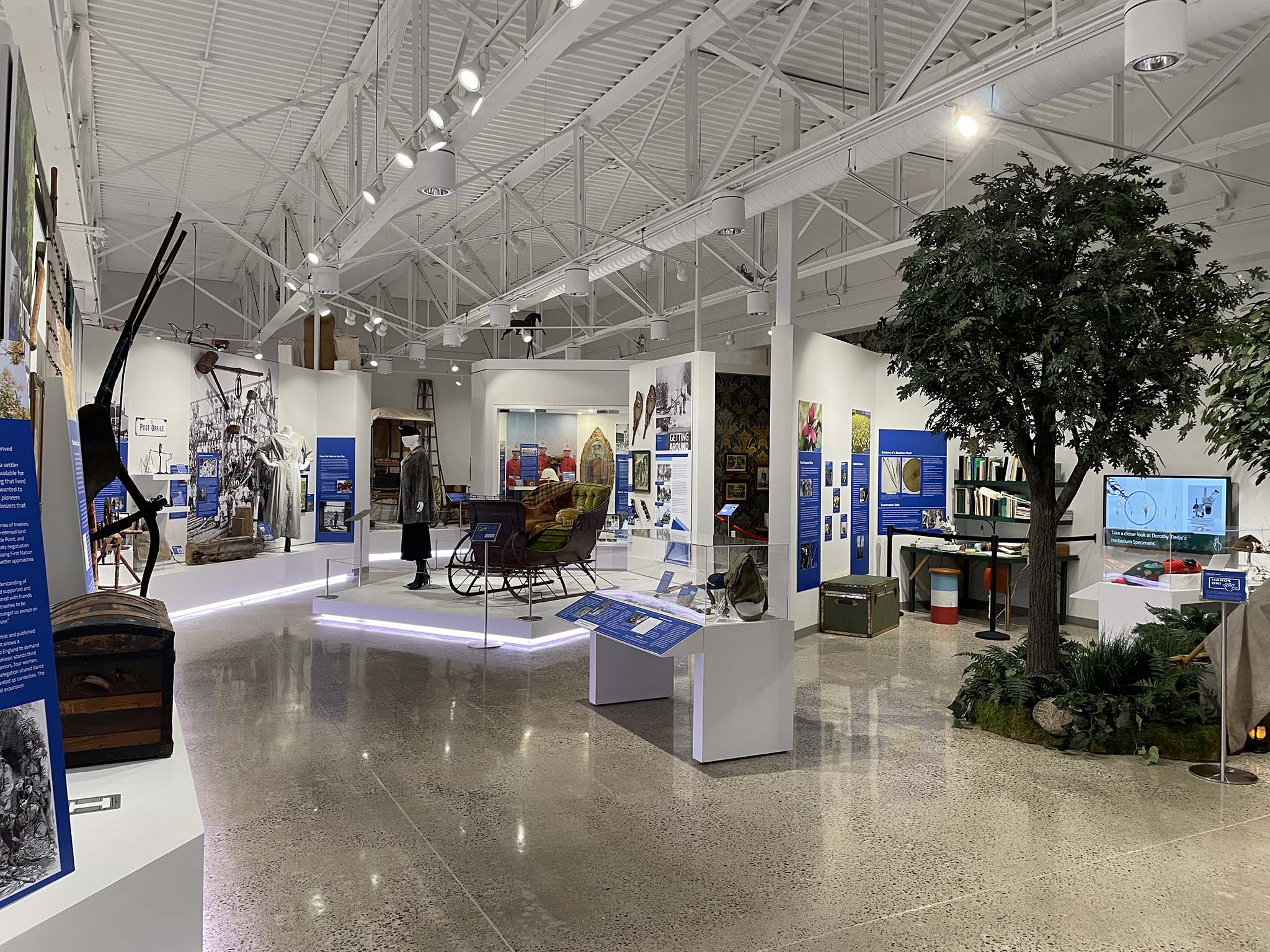 Gallery at Lambton Heritage Museum with historic artifacts, mannequins, sleighs, and displays.