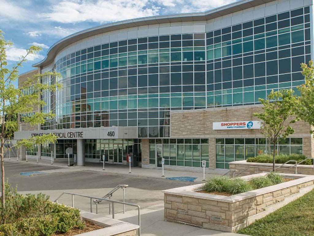 Springbank Medical 1 Exterior of the Springbank Medical Centre in London, Ontario, showing the three-storey glass façade with Shoppers Drug Mart on the ground level.