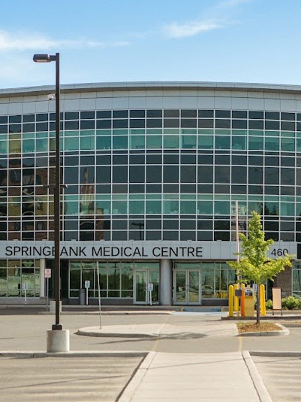 Springbank Medical 8 Front entrance of the Springbank Medical Centre with glass exterior and surrounding parking area.
