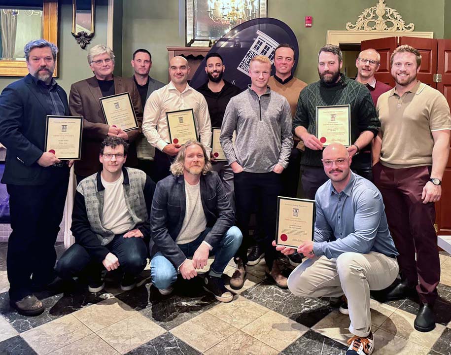 Group of award recipients posing indoors with framed certificates at the Frontenac Heritage Conservation Awards.
