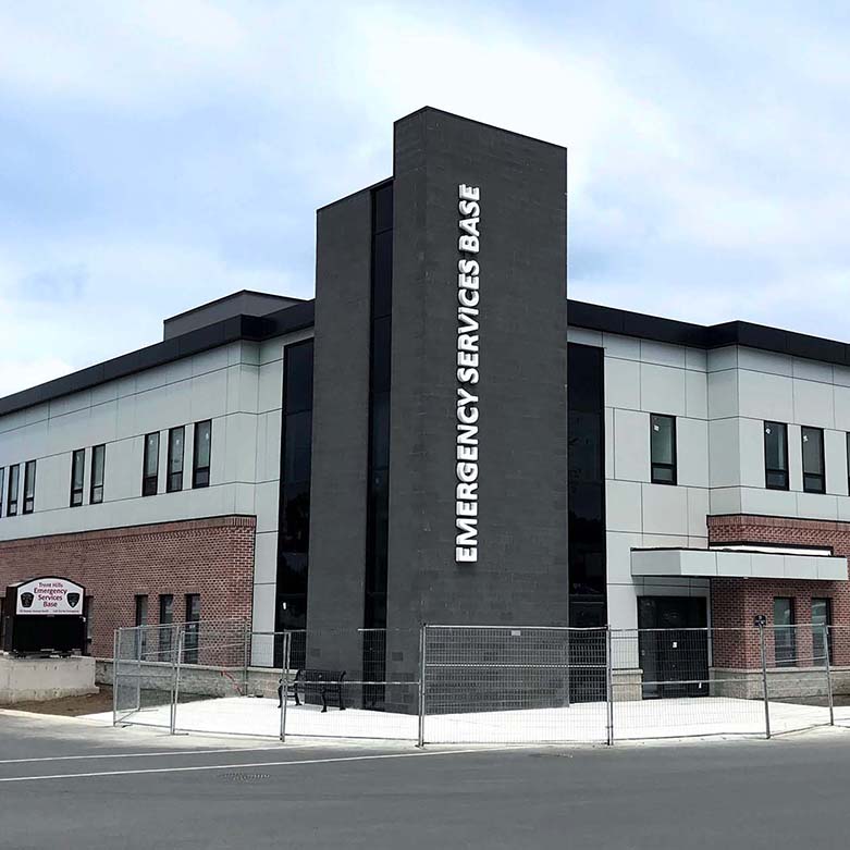 Exterior view of the Trent Hills Emergency Response Centre showing the two storey brick and panel building with the “Emergency Services Base” tower facing the street.