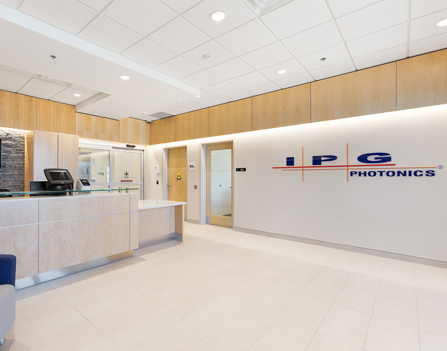 IPG Photonics reception area with front desk, wood finishes, and company logo on the wall.